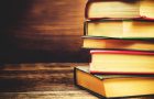 stack of books on the dark wood background. toning. selective focus on the middle book