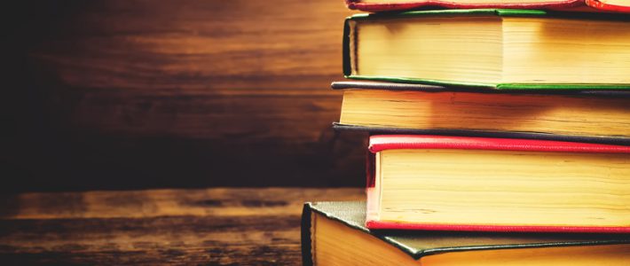 stack of books on the dark wood background. toning. selective focus on the middle book
